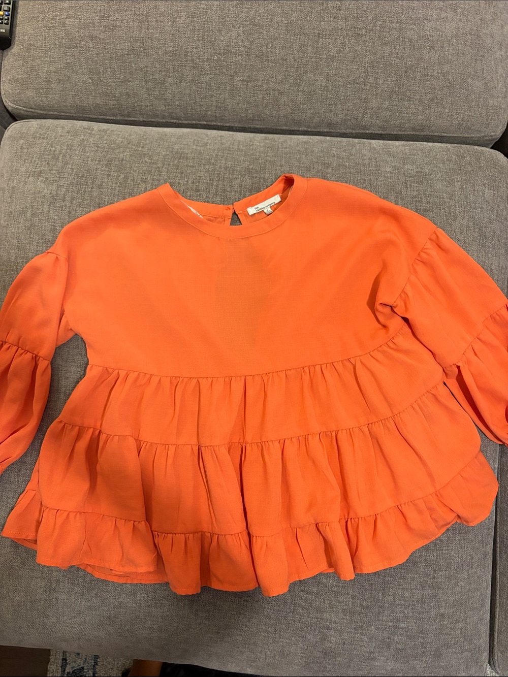 the clothing company Bright Orange Tiered Ruffle Blouse